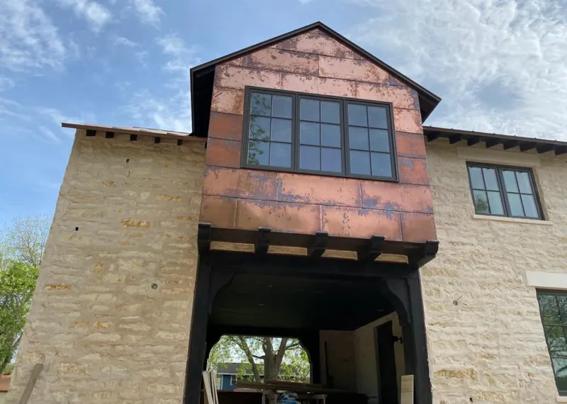 Copper metal panel facade on a stone building for Roof Repair in Hot Springs Village