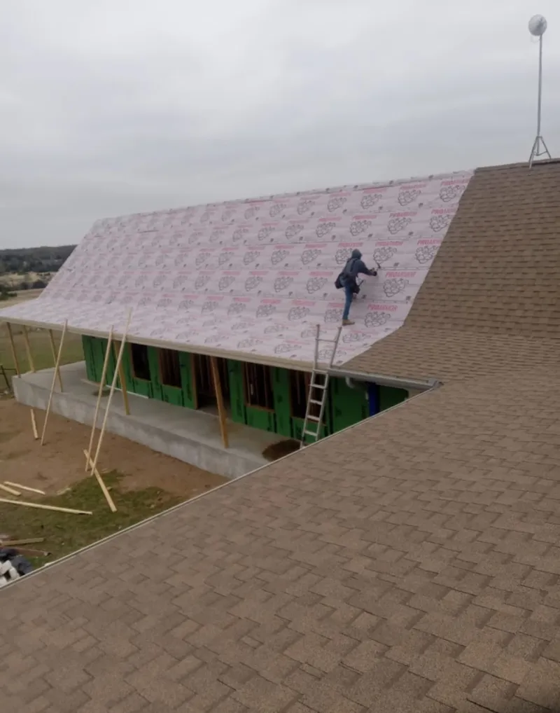 Worker preparing underlayment for a metal roof installation in Hot Springs Village